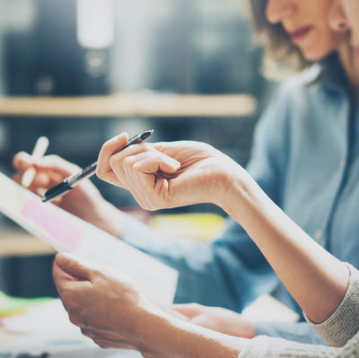 People pointing at notes with pens