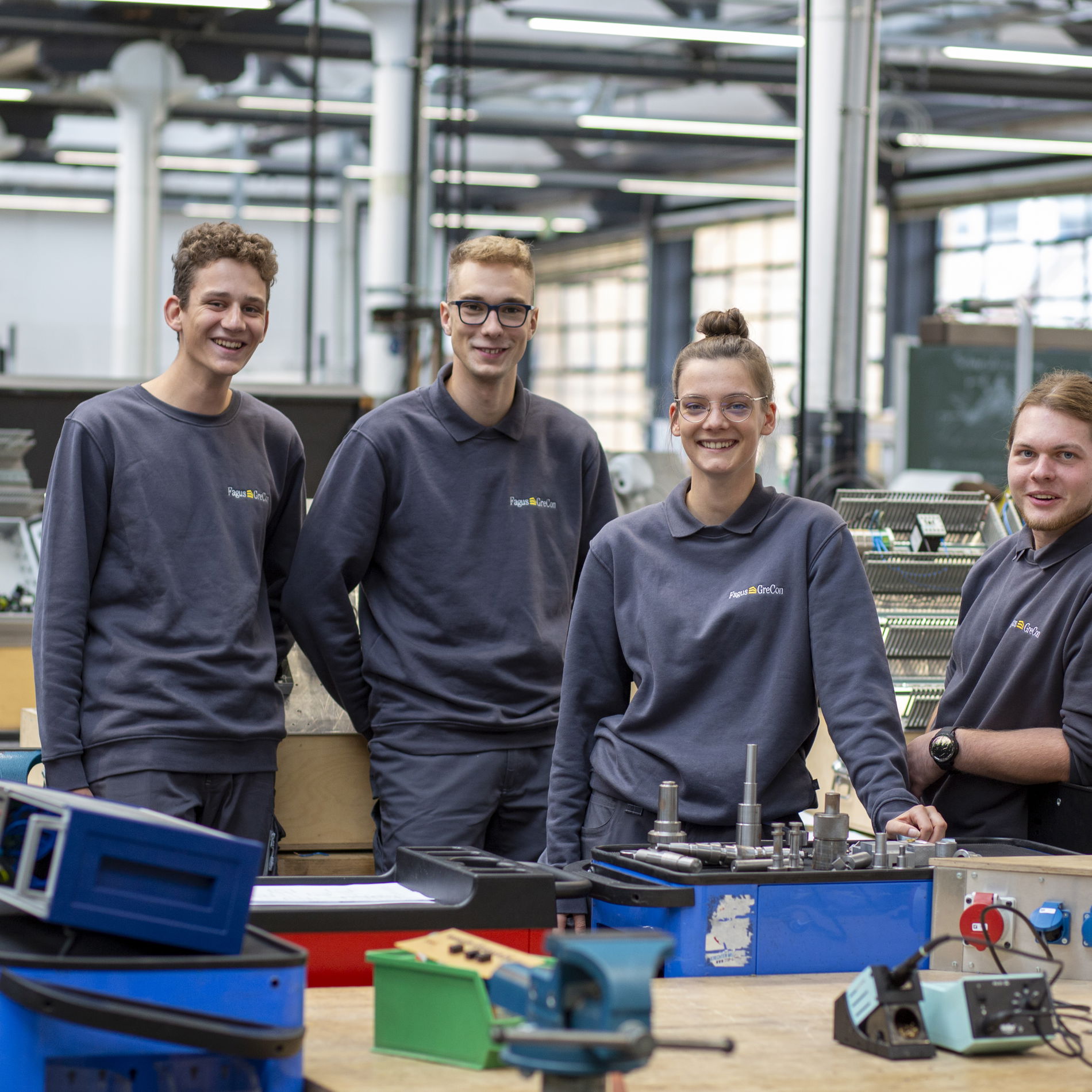 Trainees wearing grey jumpers in workshop