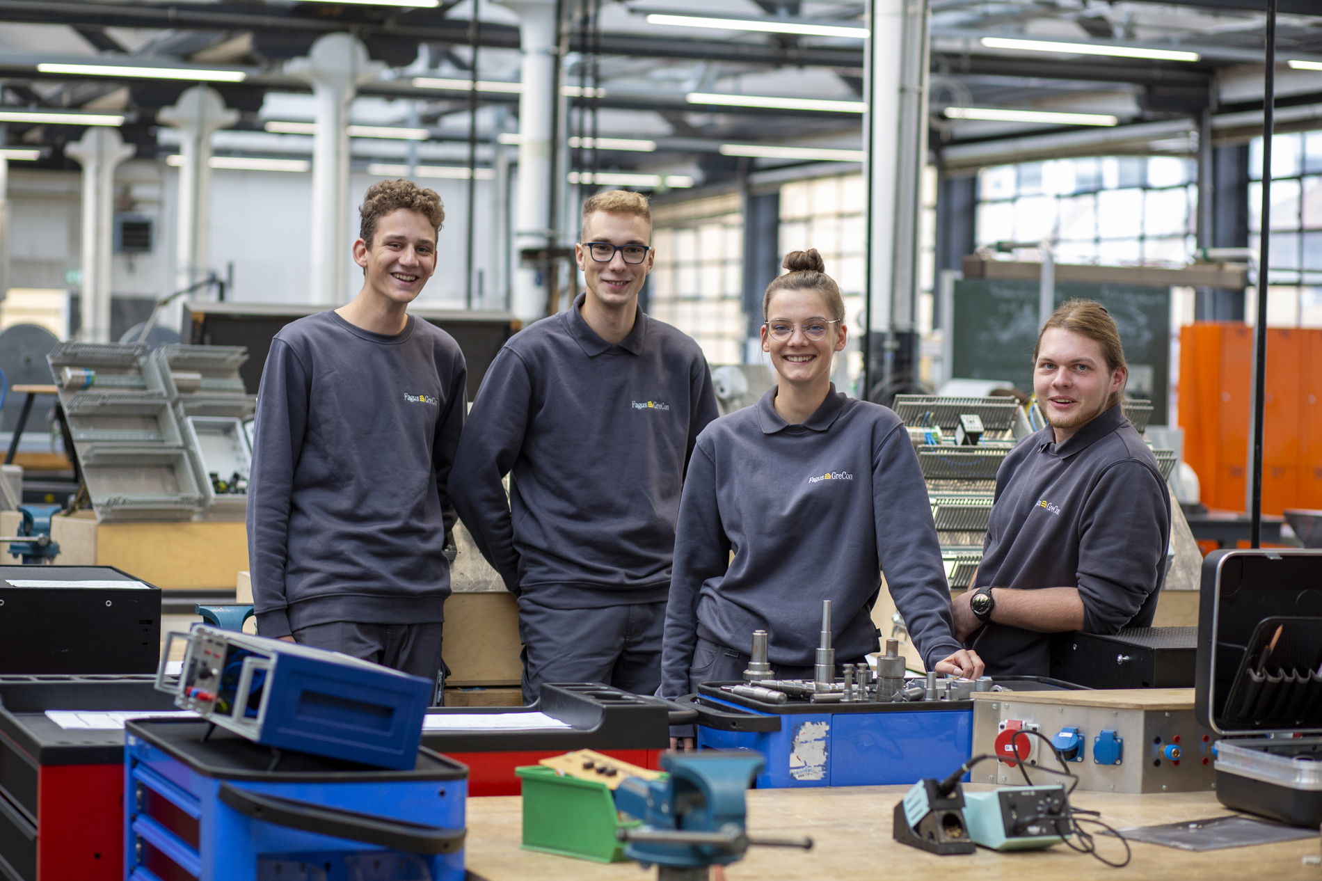Trainees wearing grey jumpers in workshop