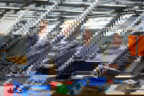 Trainees wearing grey jumpers in workshop