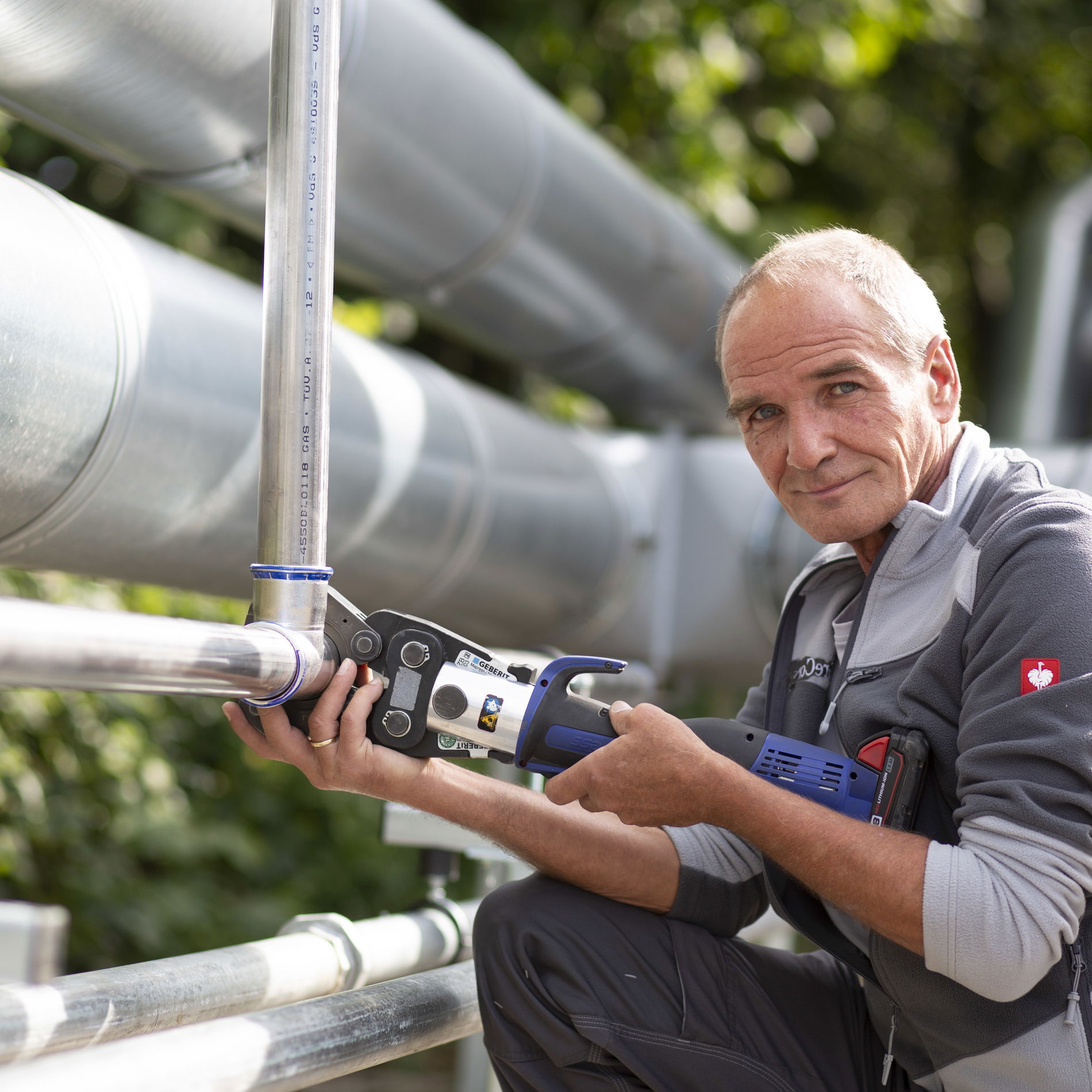 Man in front of a pipe with tools