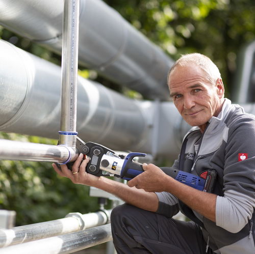 Man in front of a pipe with tools