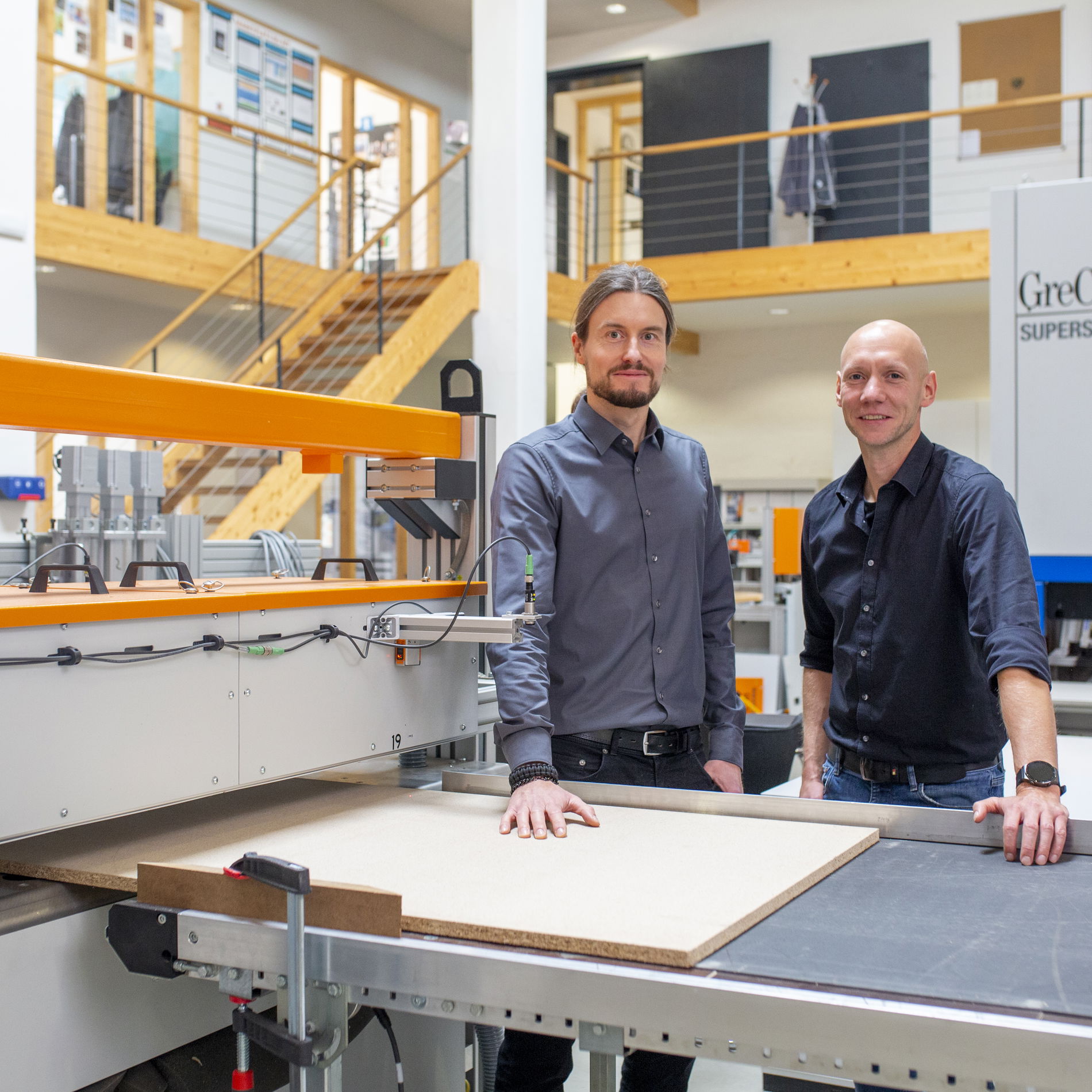 Two people standing in front of measurement technology product