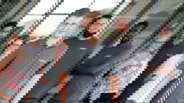 Trainee wearing a grey polo shirt standing in front of other trainees