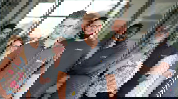 Trainee wearing a grey polo shirt standing in front of other trainees