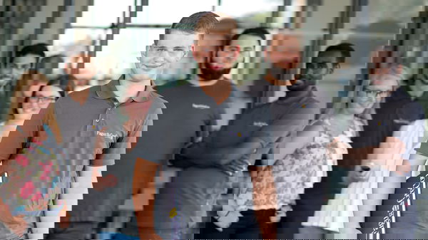 Trainee wearing a grey polo shirt standing in front of other trainees