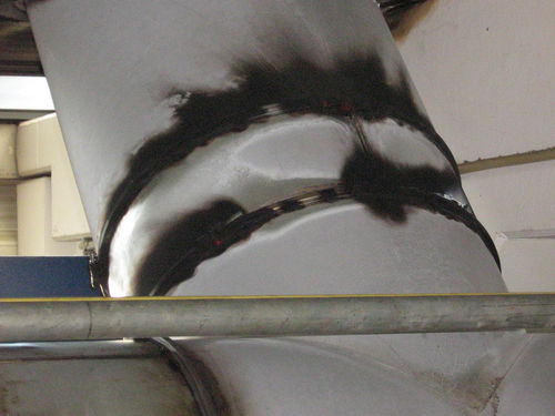 Soot on the outside of a large pipe