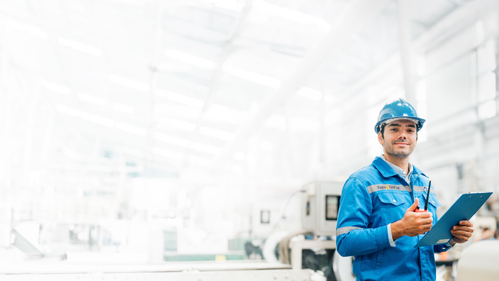 Worker in blue GreCon outfit with clipboard and helmet