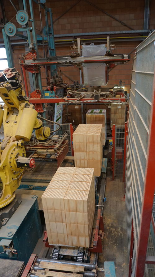 A pile of bricks next to an industrial robot arm