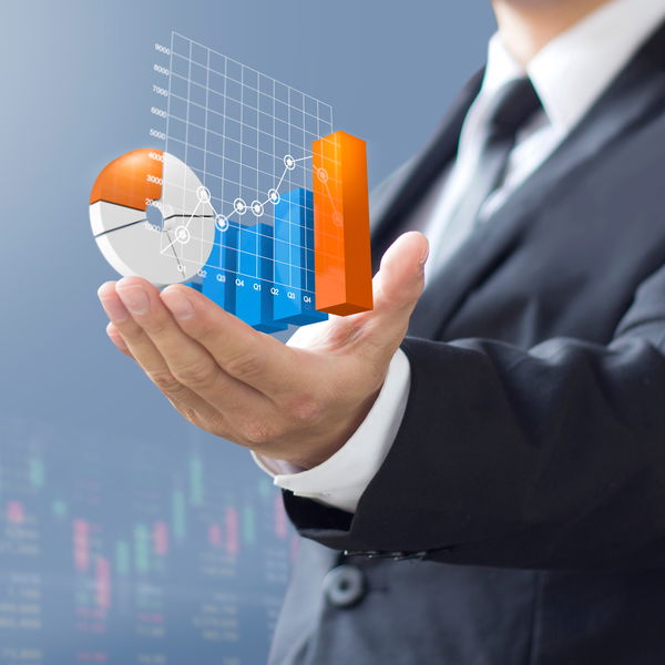 Man in suit holding various diagrams in his hand