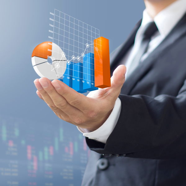 Man in suit holding various diagrams in his hand
