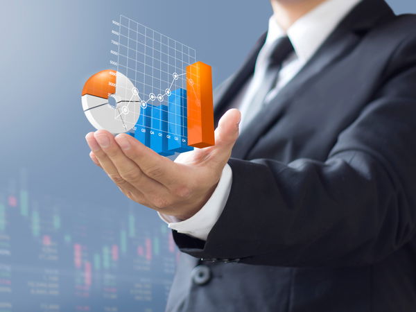 Man in suit holding various diagrams in his hand