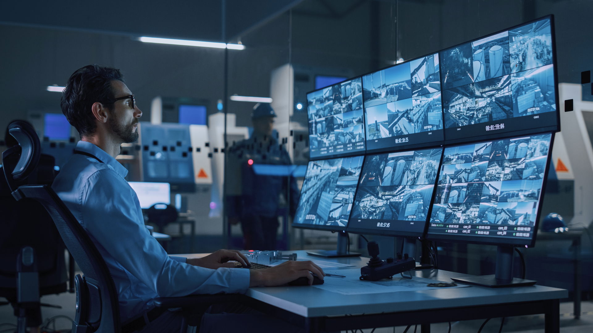 Man sits in front of numerous monitors and monitors