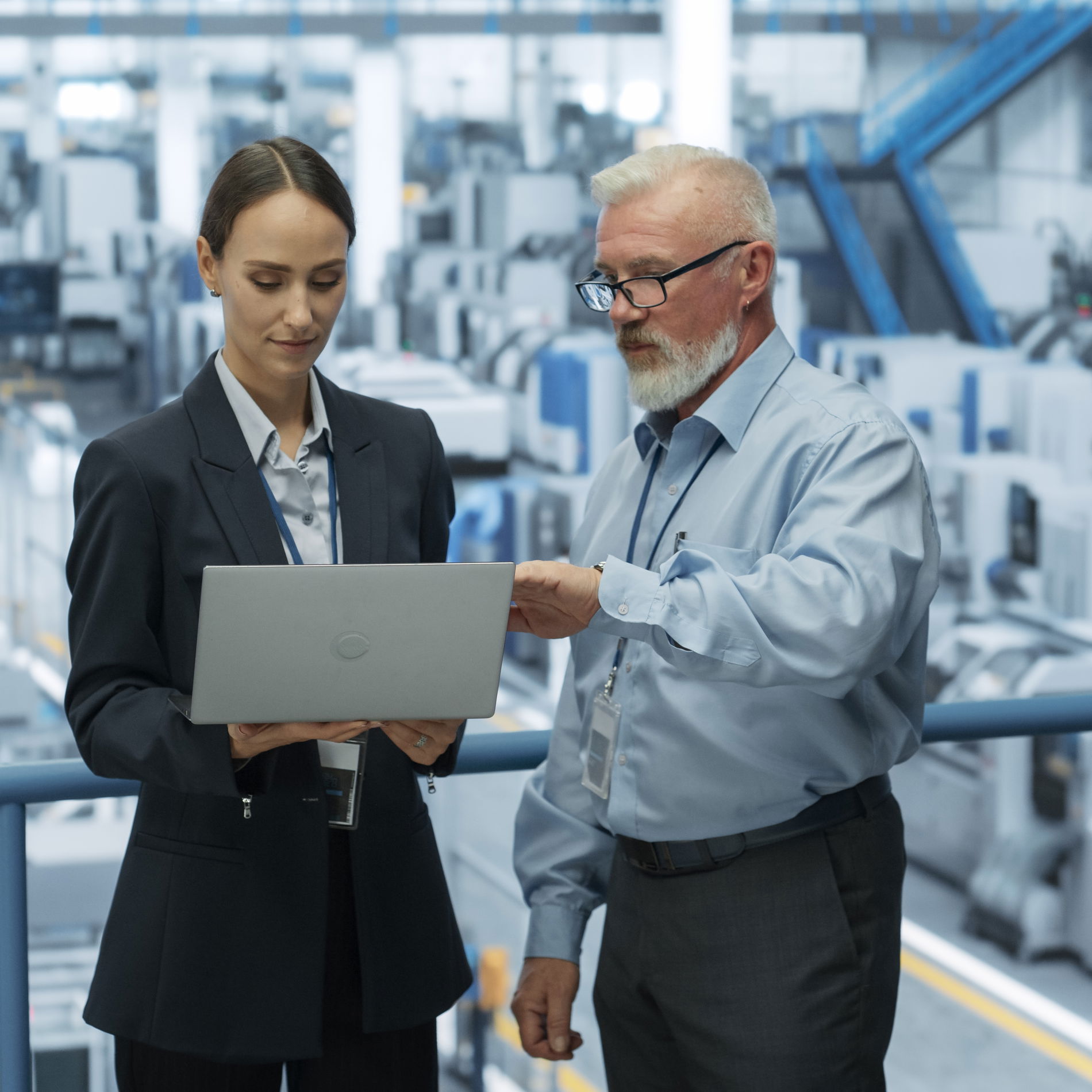Woman and man looking at a laptop monitor in front of an industrial building