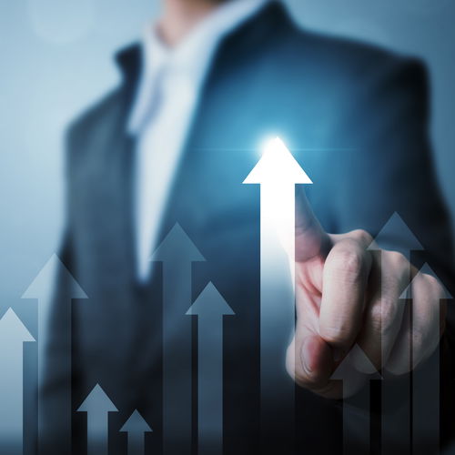 Man in suit pointing with his finger at a glowing upward arrow