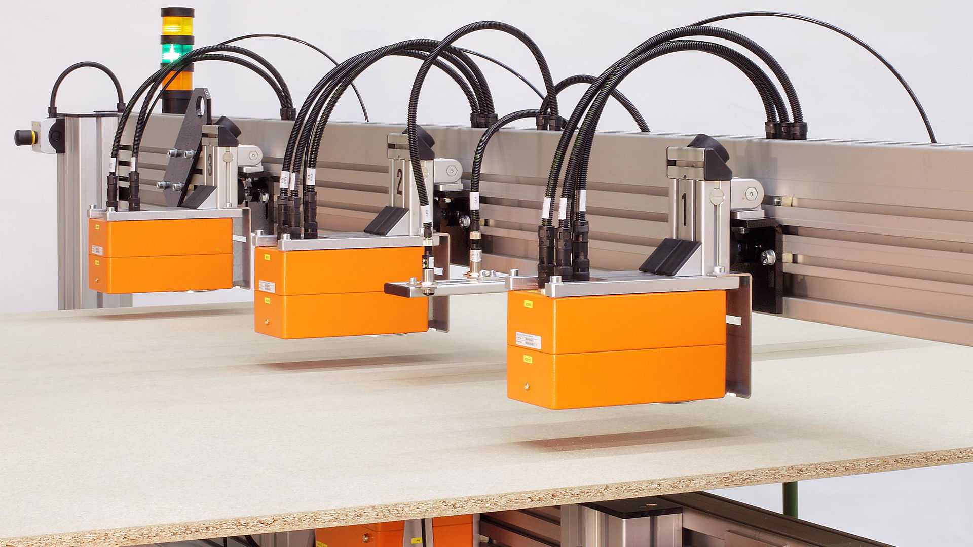 GreCon BOARDSCALE product as an orange X-ray scanner above the production line.