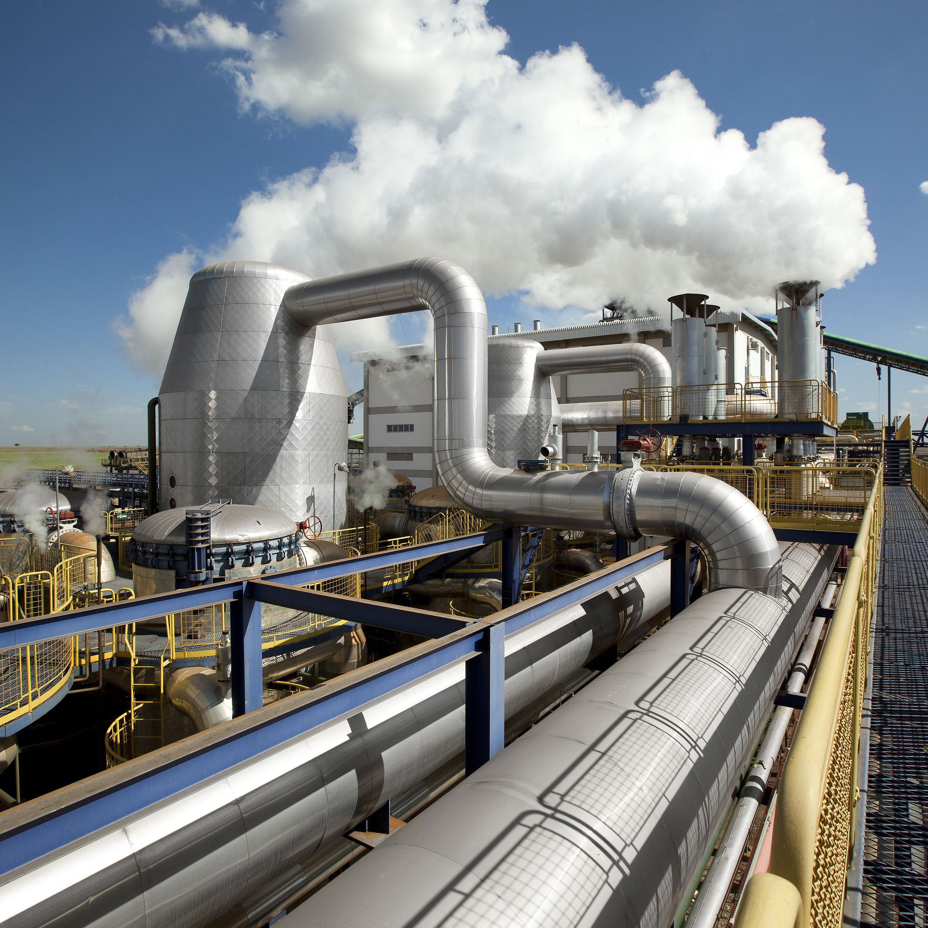 Large-scale industrial sugar production with pipes, stairs and steam