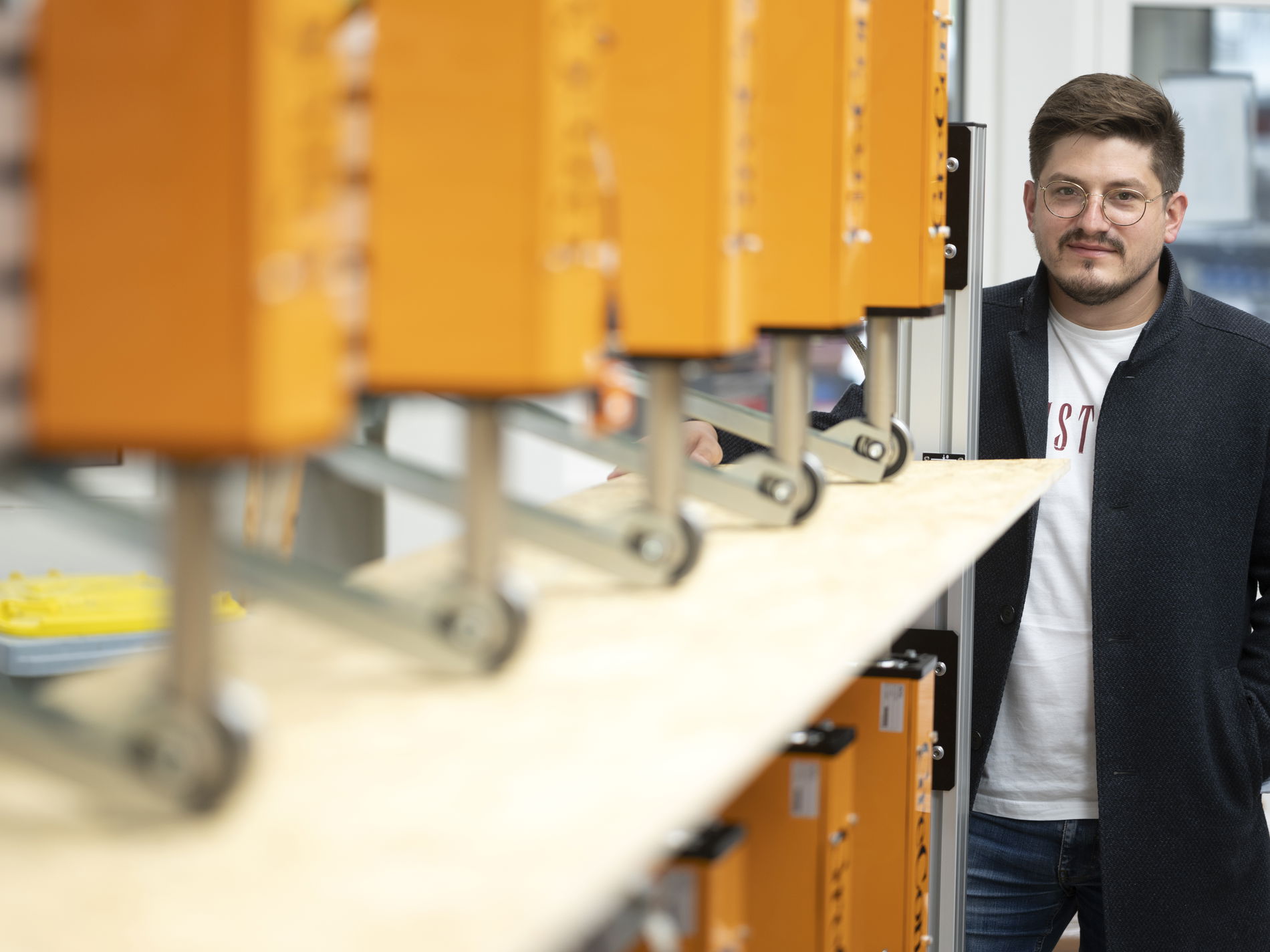 GreCon THICKNESSCONTROL RT with contact measuring heads on production line with person in perspective