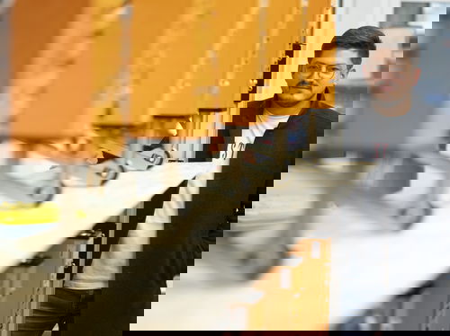 GreCon THICKNESSCONTROL RT with contact measuring heads on production line with person in perspective