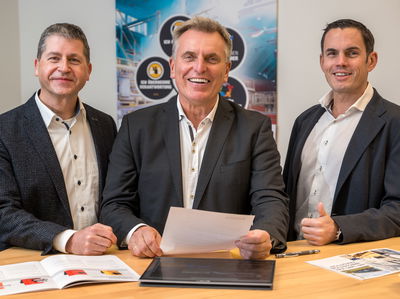 Drei Geschäftsführer von Fagus-GreCon vor Stehtisch.